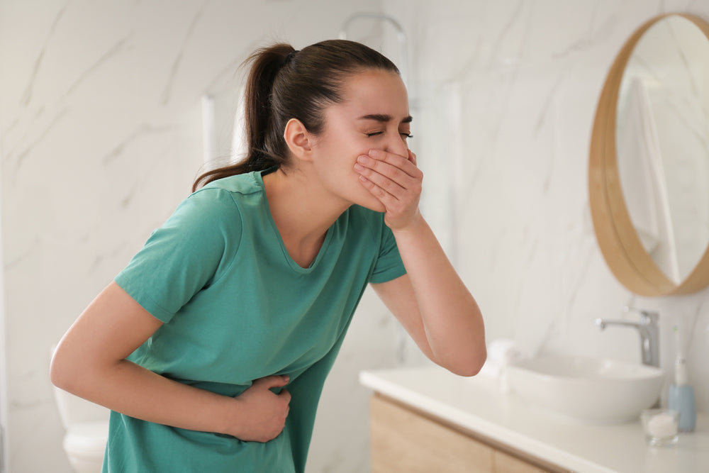 Femme ressentant des nausées et se tenant le ventre